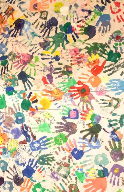 a canvas with multicolored handprints in all directions